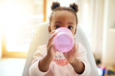 Buy stock photo Little girl, portrait and baby drinking with bottle on chair for meal, hydration or snack at home. Black child, kid or daughter with mineral liquid, vitamin or nutrition for food supplement at house