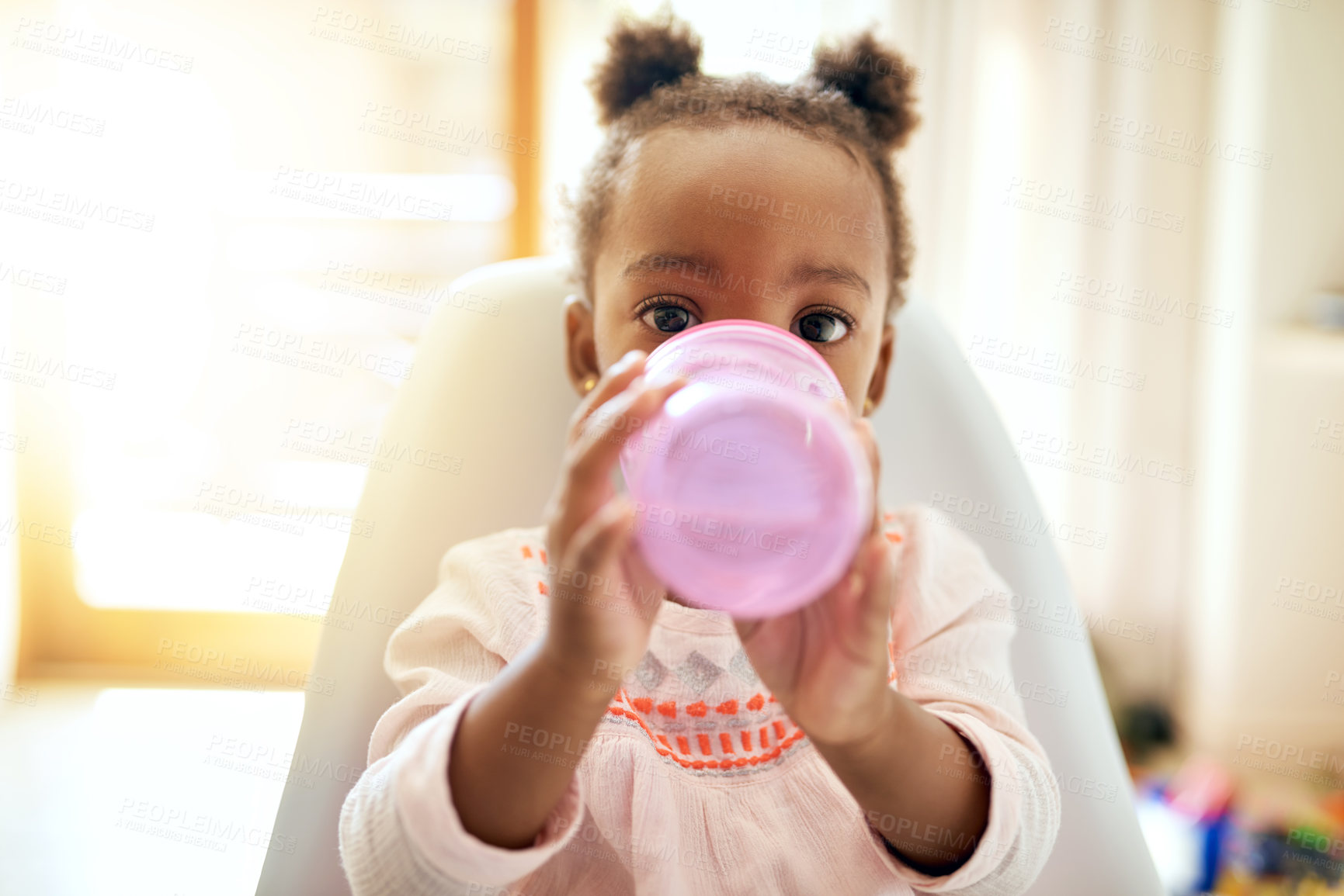 Buy stock photo Little girl, portrait and baby drinking with bottle on chair for meal, hydration or snack at home. Black child, kid or daughter with mineral liquid, vitamin or nutrition for food supplement at house