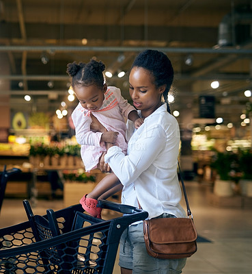 Buy stock photo Black family, mother and baby with trolley for shopping in cart together at grocery store. African mom with daughter, child or little girl in shop carriage for commerce together at indoor supermarket