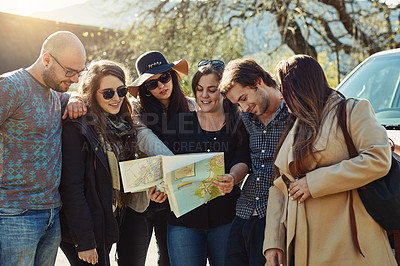 Buy stock photo Cropped shot of a group of friends looking at a map while on a road trip