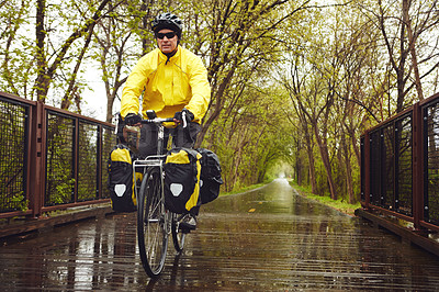 Buy stock photo Full length shot of a male cyclist enjoying a bike ride on a wet winter's morning