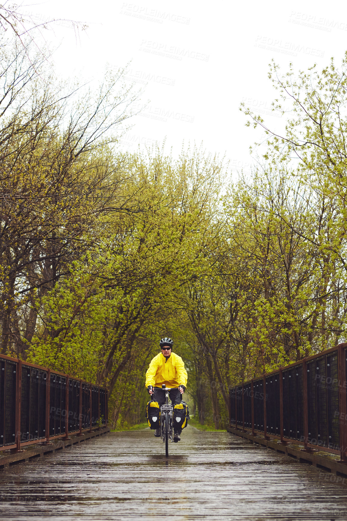 Buy stock photo Full length shot of a male cyclist enjoying a bike ride on a wet winter's morning