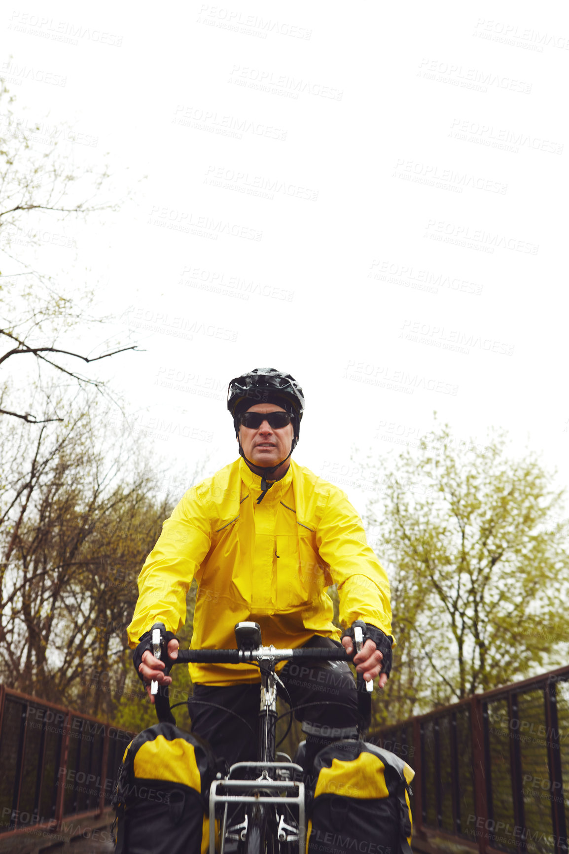 Buy stock photo Cropped shot of a male cyclist enjoying a bike ride on a wet winter's morning