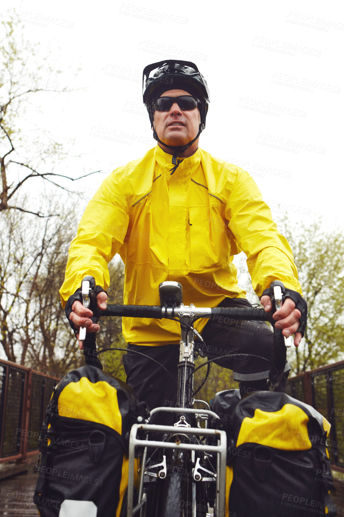 Buy stock photo Cropped shot of a male cyclist enjoying a bike ride on a wet winter's morning