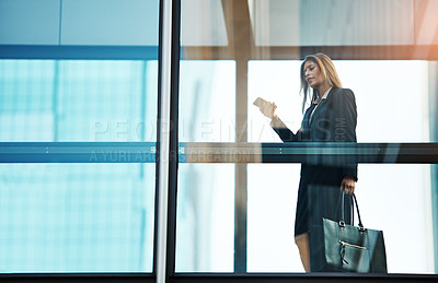 Buy stock photo Shot of a businesswoman using a mobile phone in a modern glass office