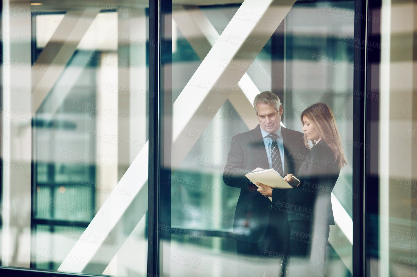 Buy stock photo Shot of a businessman and businesswoman having a discussion in a modern office