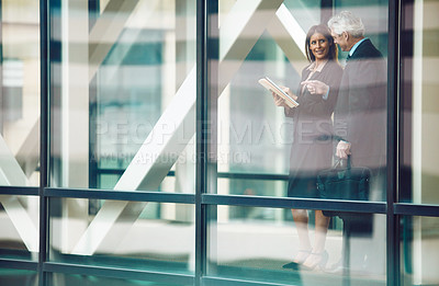 Buy stock photo Shot of a businessman and businesswoman having a discussion in a modern office