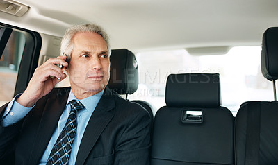 Buy stock photo Shot of a mature businessman using a mobile phone in the back seat of a car