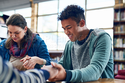 Buy stock photo Shot of a group of university student praying together while sitting in a library