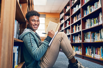 Buy stock photo Shot of a university student doing research in the library