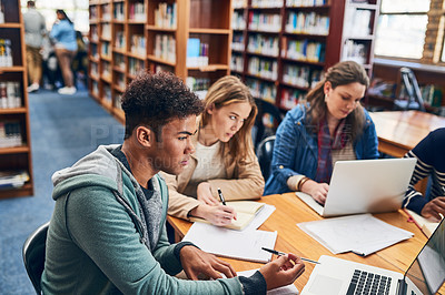Buy stock photo Cropped shot of a group of university student studying hard in a library