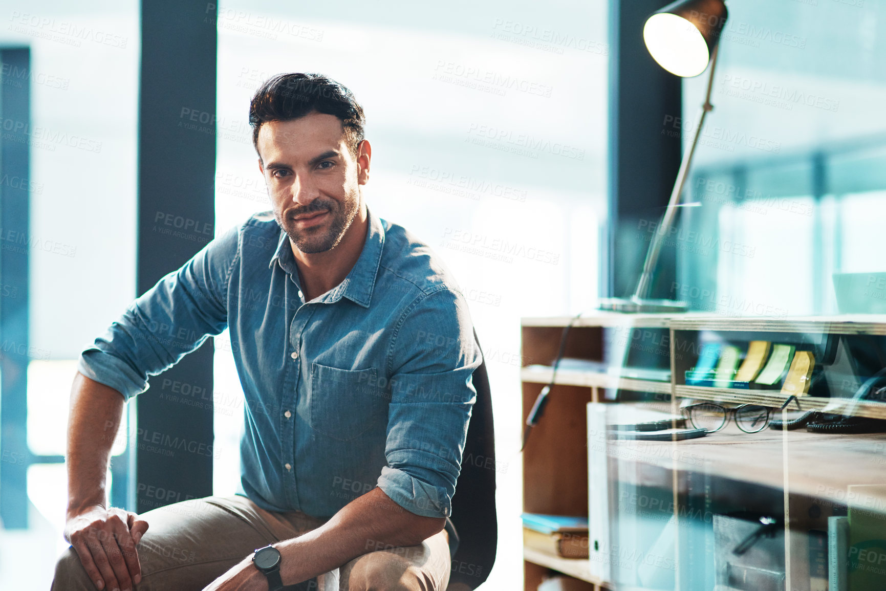 Buy stock photo A confident, serious and powerful male entrepreneur sitting in a modern office or workplace. Portrait of a business man, leader or employer ready to be successful looking at the camera