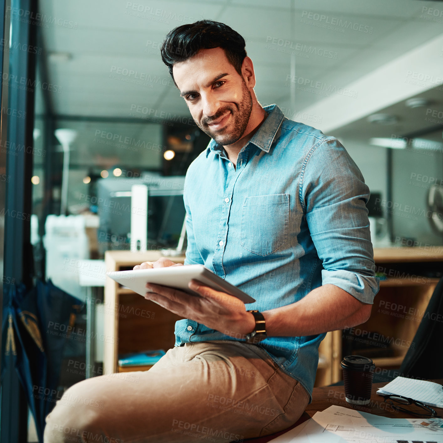 Buy stock photo Confident businessman with tablet holding, browsing and searching online while working overtime on startup company. Portrait of smiling, happy and successful creative finishing deadline on technology