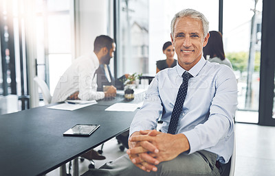 Buy stock photo Corporate, portrait and mature businessman in meeting or conference and sitting in boardroom with his coworkers. Mentor, manager and senior man with his team in office planning together in workplace
