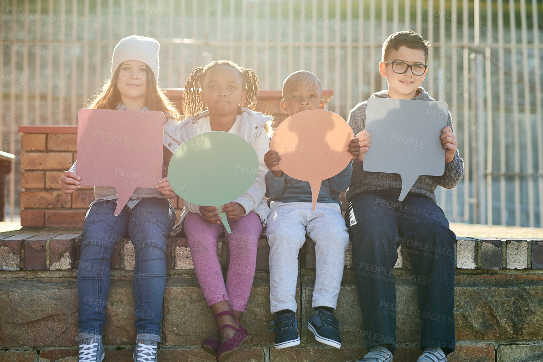 Buy stock photo Children, speech bubble and outdoor for portrait at school on brick wall with voice, opinion and social media. Kids, friends and happy with diversity, education and mock up space at academy in Canada