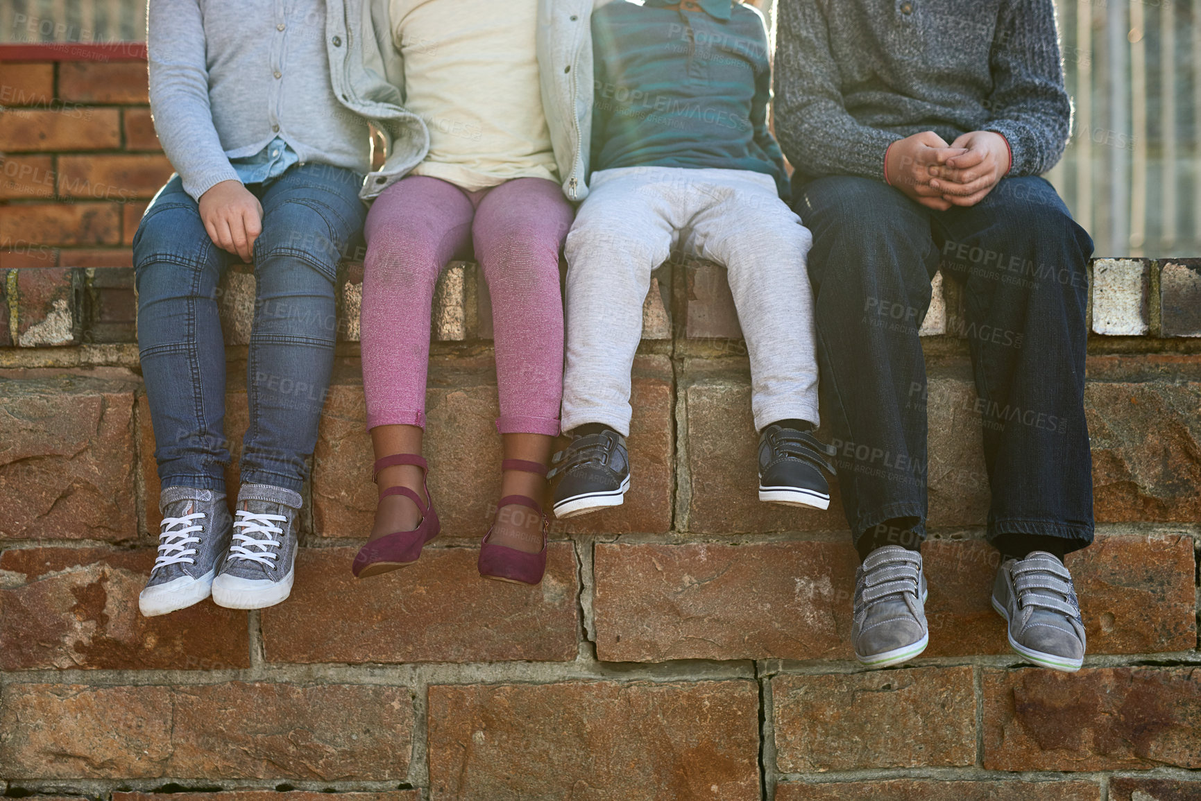 Buy stock photo Children, shoes and friends on wall at school with education, development and relax with legs at academy. Kids, group and feet with learning, scholarship and future with line, together and outdoor