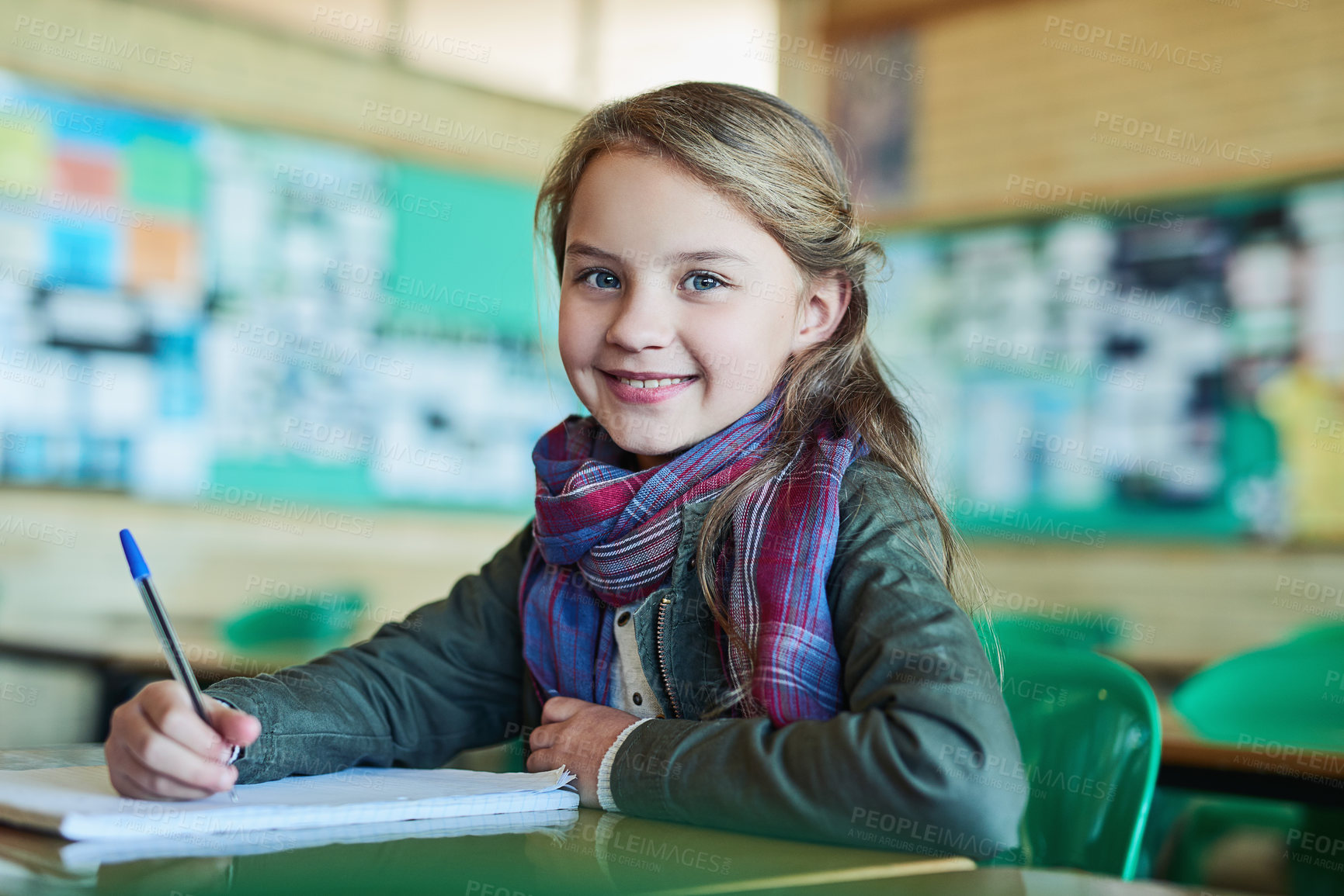 Buy stock photo Girl, portrait and writing with book in classroom for smile, notes and excited with education. Child, notebook and pride with info, scholarship or study with progress for future at school in Germany