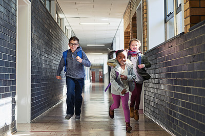 Buy stock photo Shot of a group of elementary school kids running in the corridor at school
