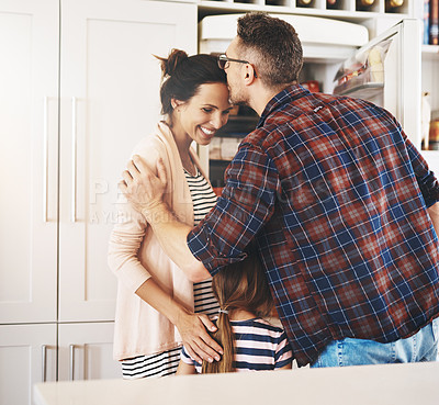 Buy stock photo Shot of a husband lovingly kissing his pregnant wife in the kitchen