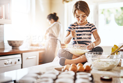 Buy stock photo Messy, flour and girl baking in a kitchen with parent for learning about Independence, child development or food at home. Dirty, fun or young female kid mixing cake or cookies in a bowl while cooking