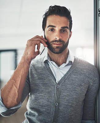 Buy stock photo Portrait of a young businessman talking on his cellphone in an office
