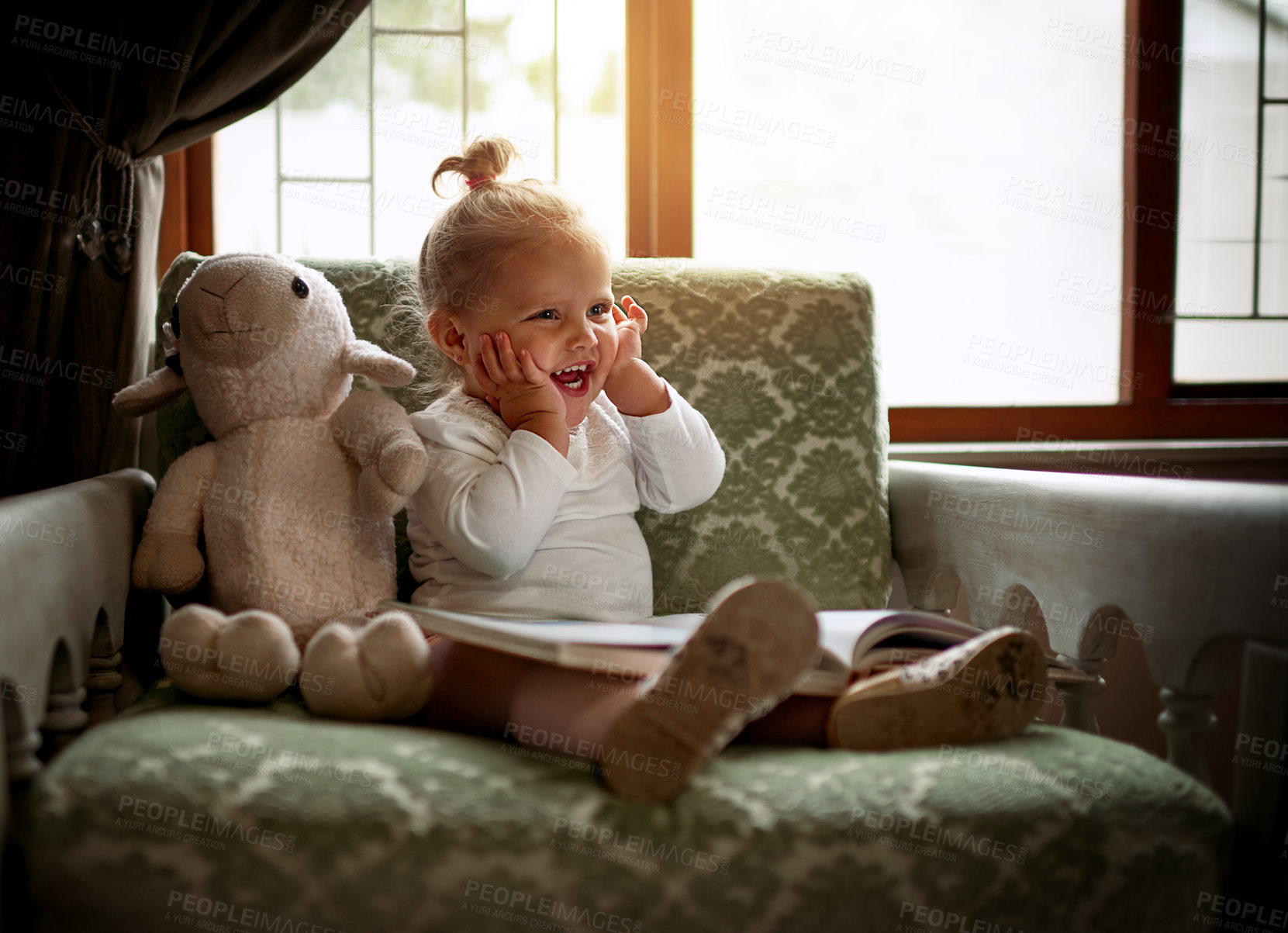 Buy stock photo Shot of an adorable little girl reading a book on the couch at home