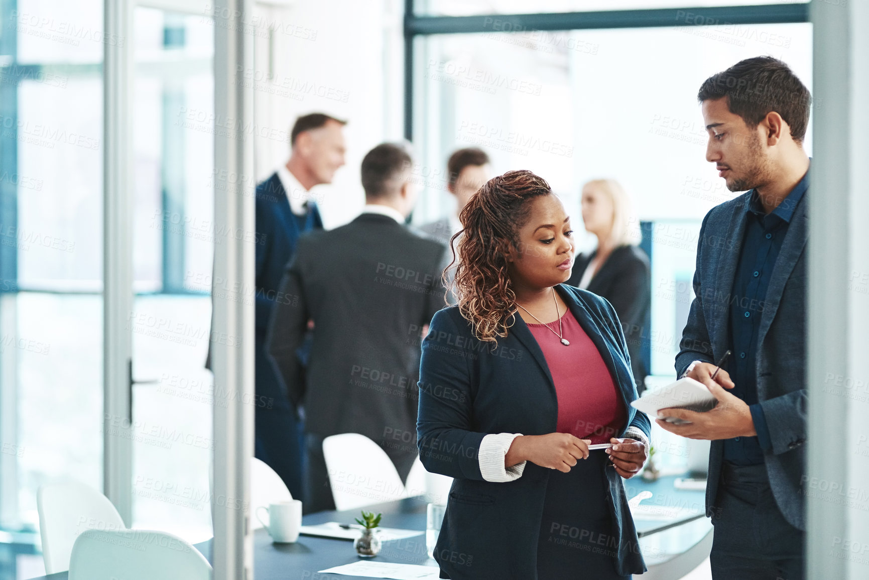 Buy stock photo Cropped shot of two corporate businesspeople talking before their meeting in the boardroom