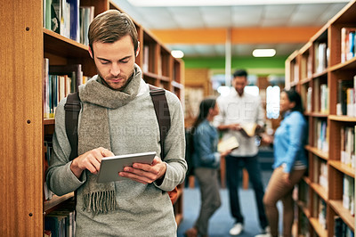 Buy stock photo Shot of a university student using a digital tablet in the library at campus