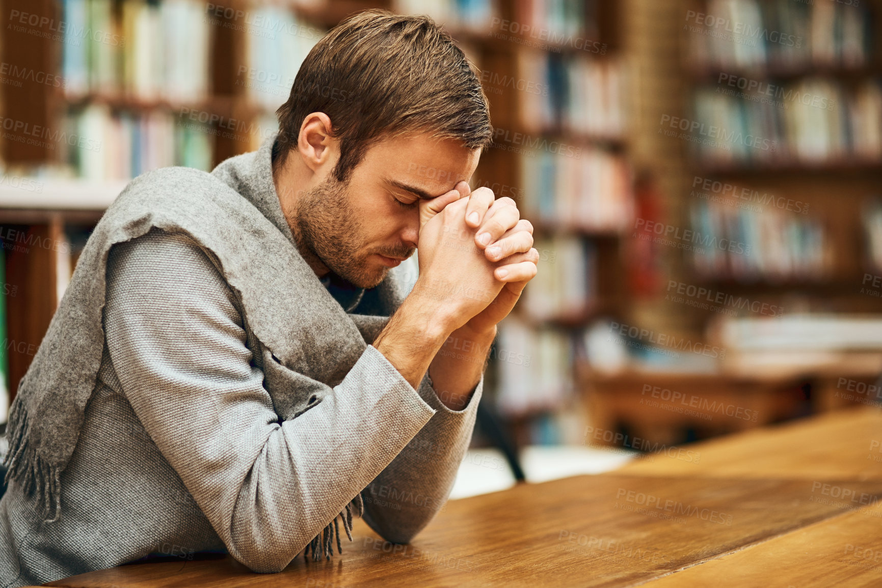 Buy stock photo Cropped shot of a handsome young man praying for help with his upcoming university exams