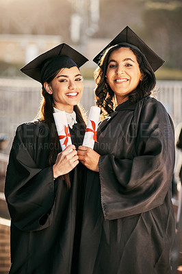 Buy stock photo Portrait of two students holding their diplomas on graduation day