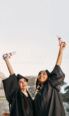 Buy stock photo Shot of two students celebrating with their diplomas on graduation day