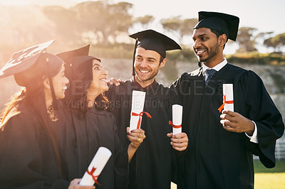 Buy stock photo Shot of a group of students celebrating with their diplomas on graduation day