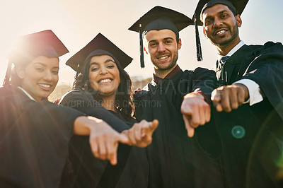 Buy stock photo Portrait of a group of students pointing forward on graduation day