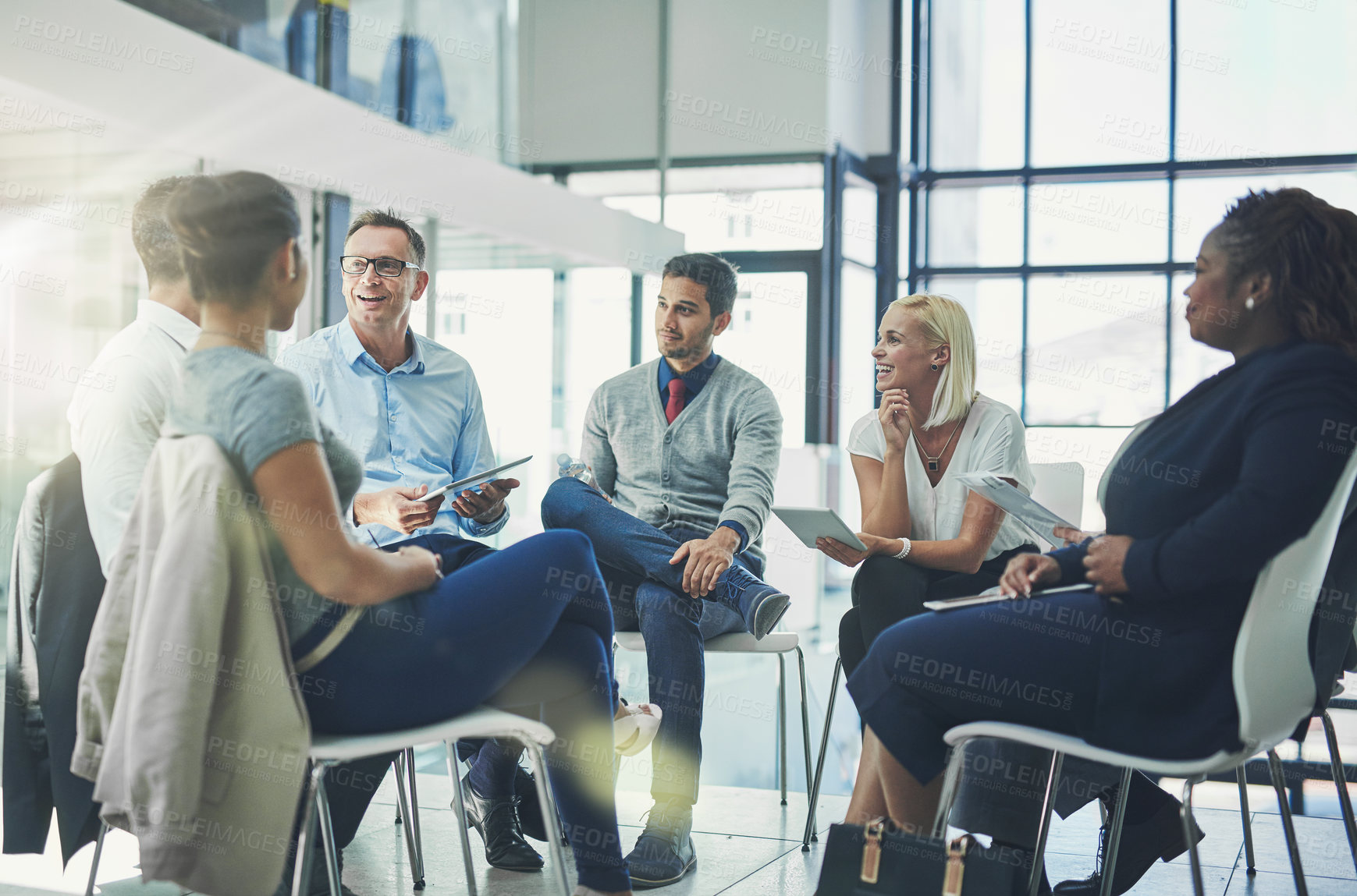 Buy stock photo Shot of a group of coworkers talking together while sitting in a circle in an office