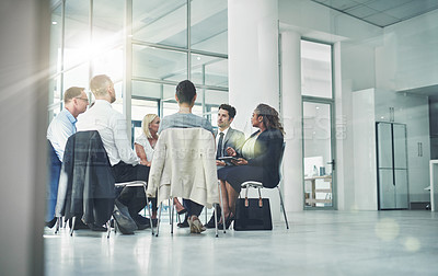 Buy stock photo Group of diverse coworkers talking together while sitting in a circle in an office. Employees having a team business meeting discussion for counseling or support group at a corporate workplace.