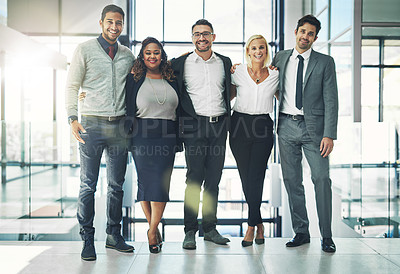 Buy stock photo Portrait of a diverse group of smiling coworkers standing arm in arm in an office