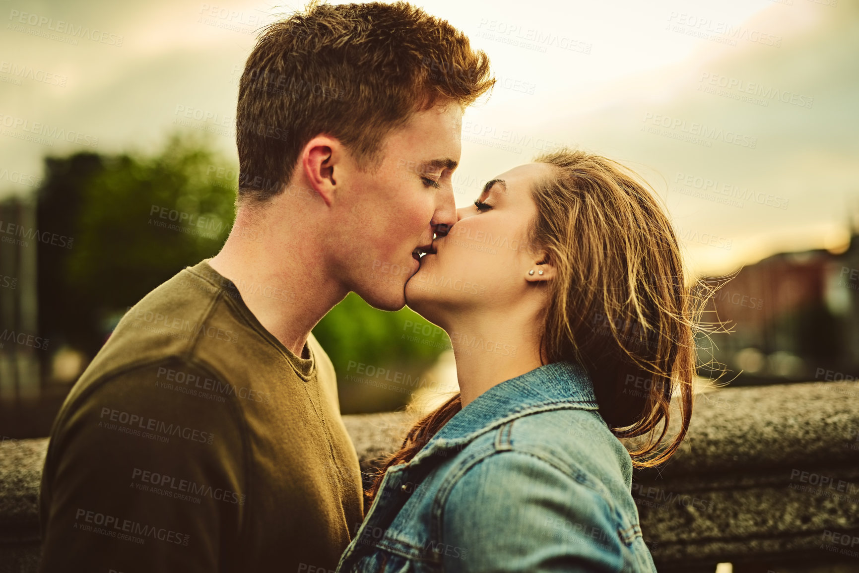 Buy stock photo Couple, kiss and embrace with love in city for affection, intimacy or support on outdoor travel together. Young man, woman or lovers touching lips for romantic date, holiday or trip in an urban town