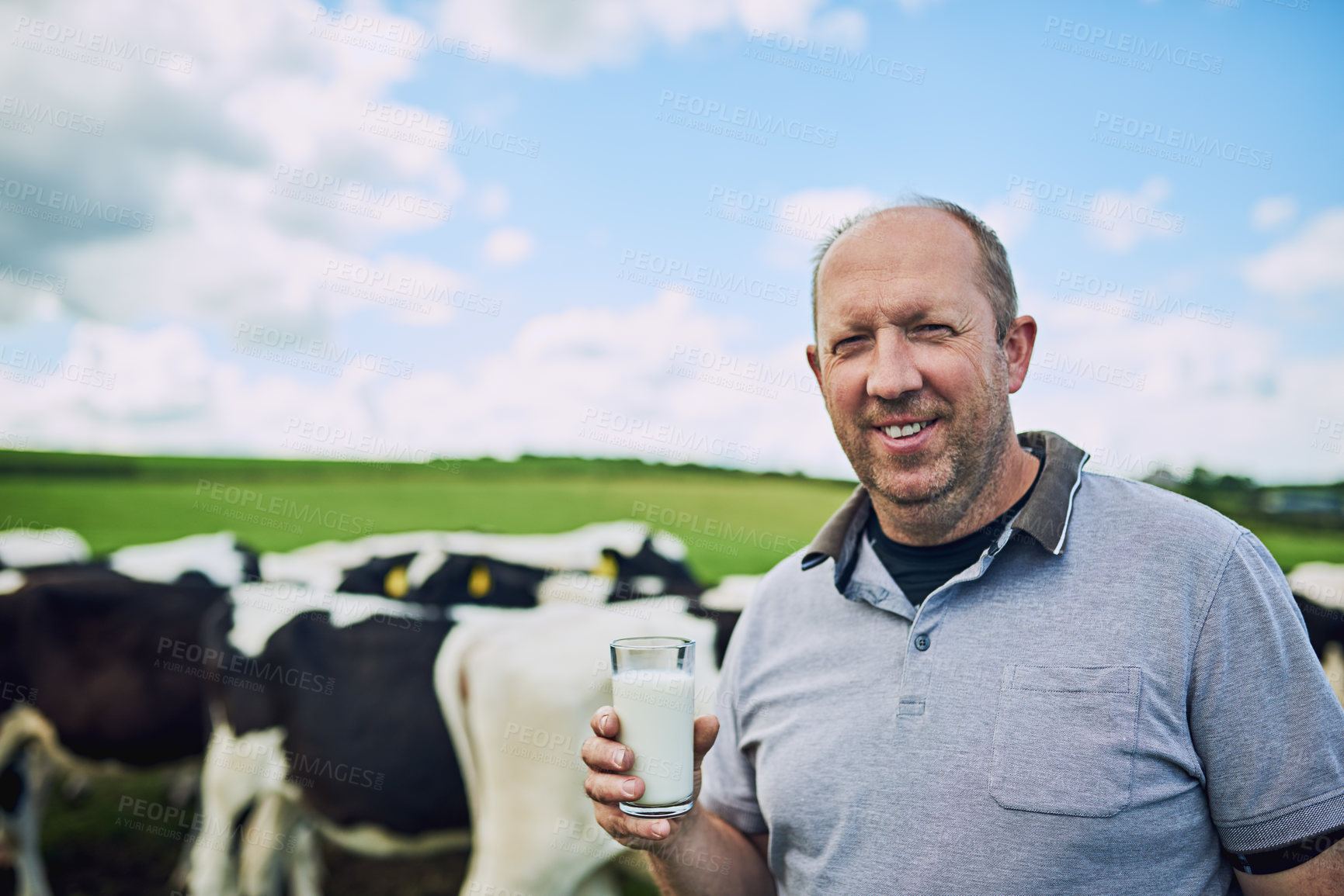 Buy stock photo Cropped portrait of a male farmer standing with a glass of milk on his dairy farm