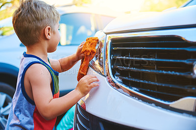 Buy stock photo Cropped shot of an adorable little boy washing a car outside