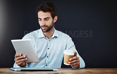 Buy stock photo Tablet, business man and drinking coffee or research in studio isolated on a black background mockup. Serious, tea and professional on tech online or agent reading email on web app for news at desk
