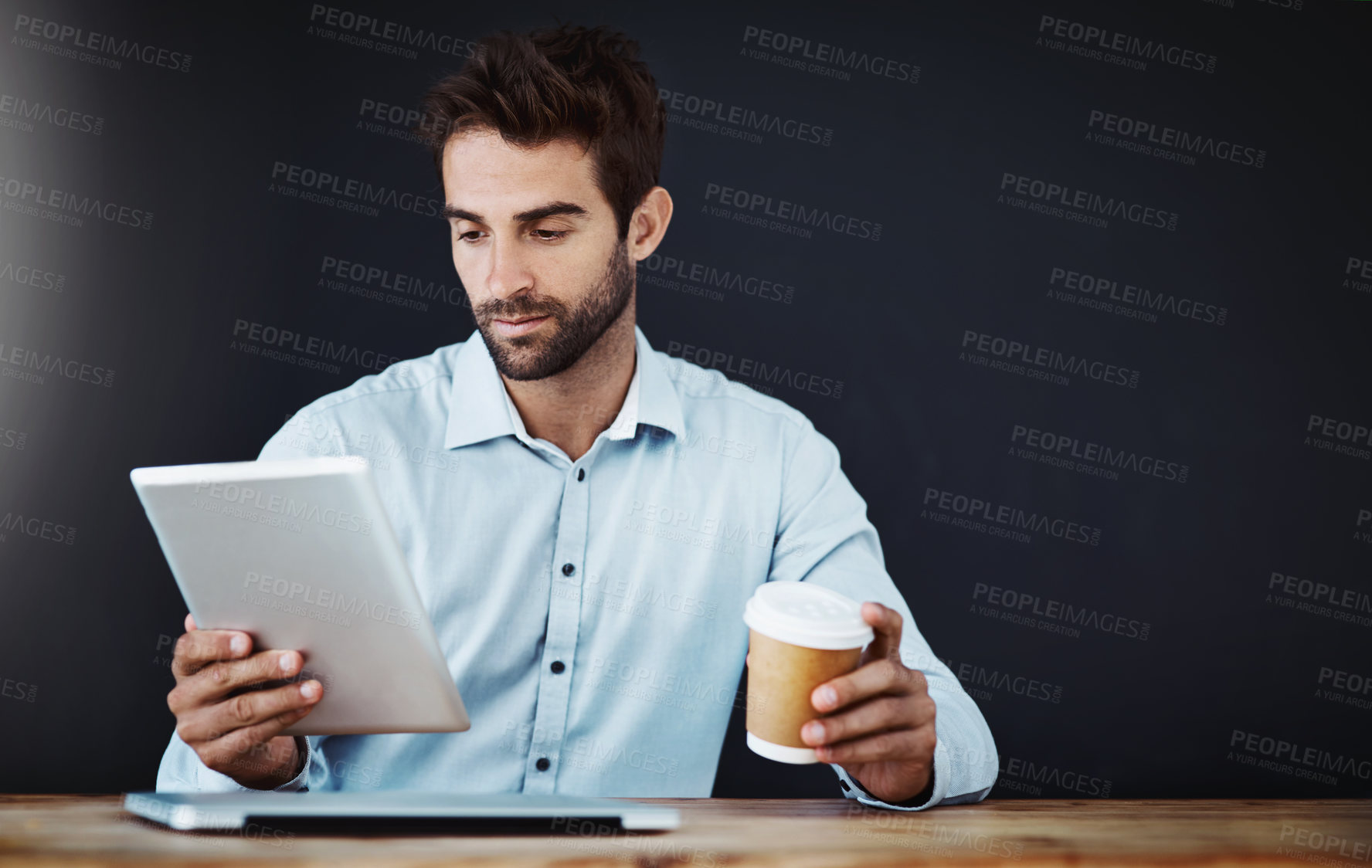 Buy stock photo Tablet, business man and drinking coffee or research in studio isolated on a black background mockup. Serious, tea and professional on tech online or agent reading email on web app for news at desk