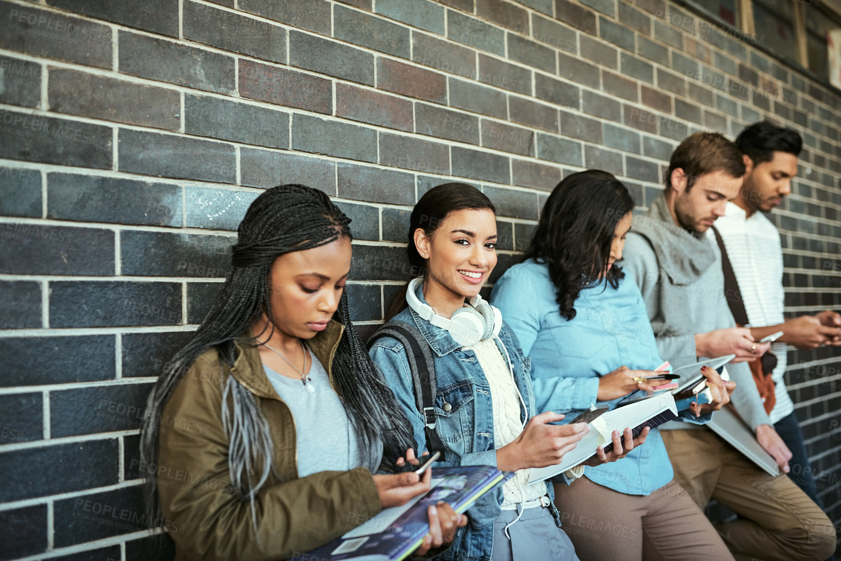 Buy stock photo Cropped portrait of an attractive young female student standing in a campus corridor with other students