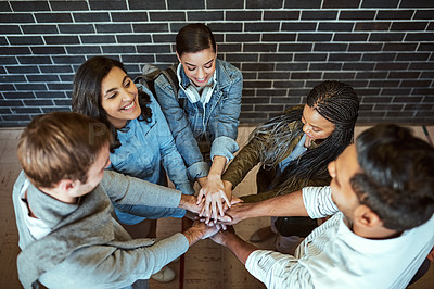 Buy stock photo High angle shot of a group of young university students standing with their hands in a huddle
