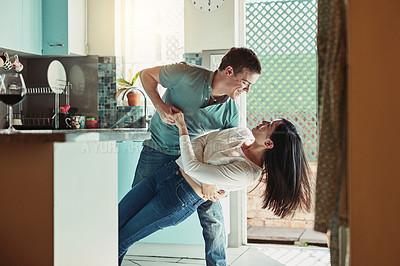 Buy stock photo Shot of a loving young couple dancing in the kitchen