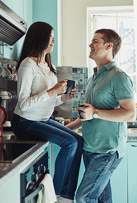 Buy stock photo Shot of a young couple chatting over coffee at home