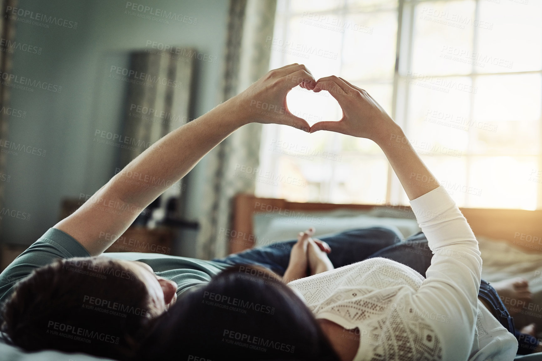 Buy stock photo Shot of a happy couple laying in bed