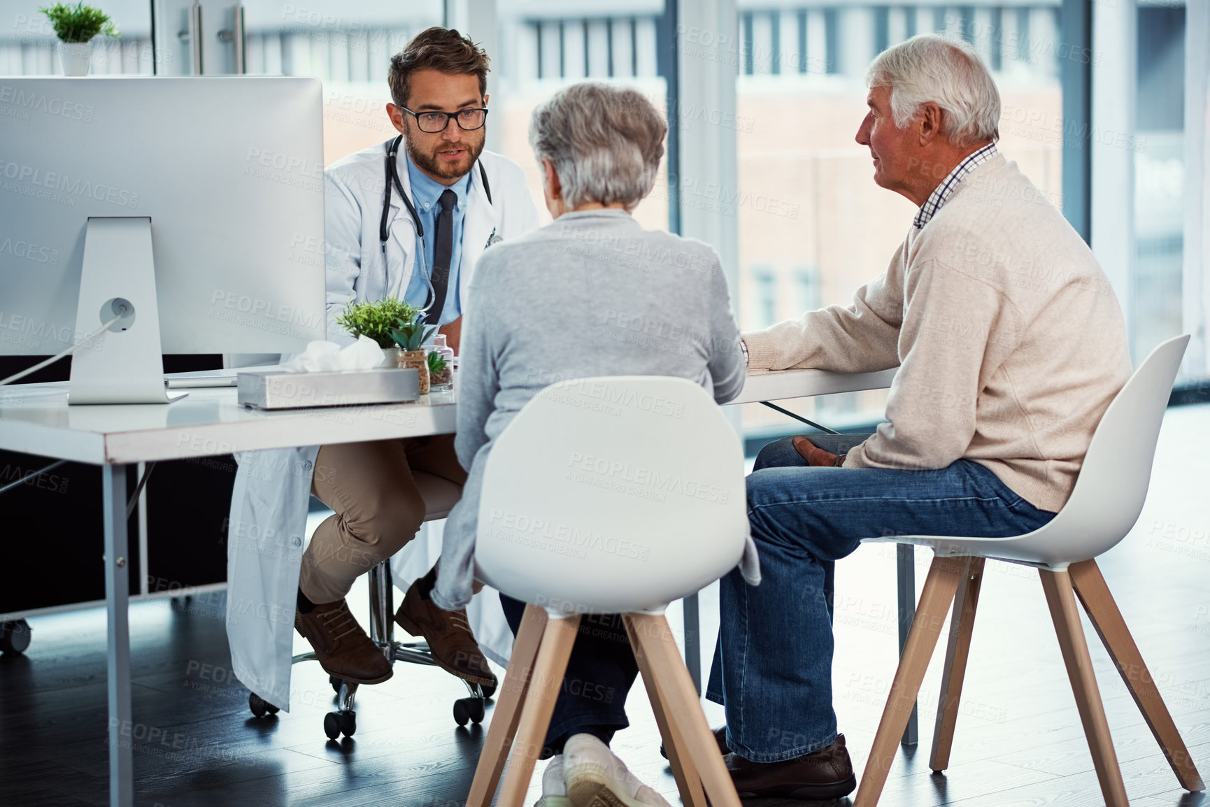 Buy stock photo Shot of a doctor having a consultation with a senior couple in a clinic