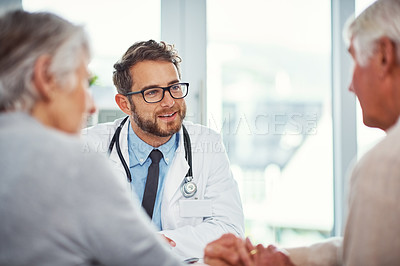 Buy stock photo Shot of a doctor having a consultation with a senior couple in a clinic