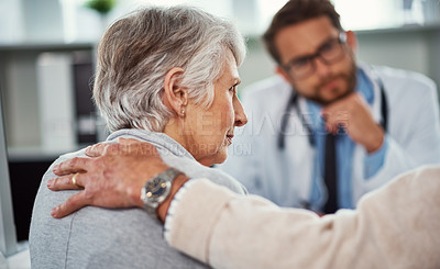 Buy stock photo Shot of a senior man consoling his wife during a consultation with a doctor in a clinic