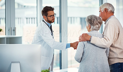 Buy stock photo Shot of a doctor meeting with a senior couple in a clinic